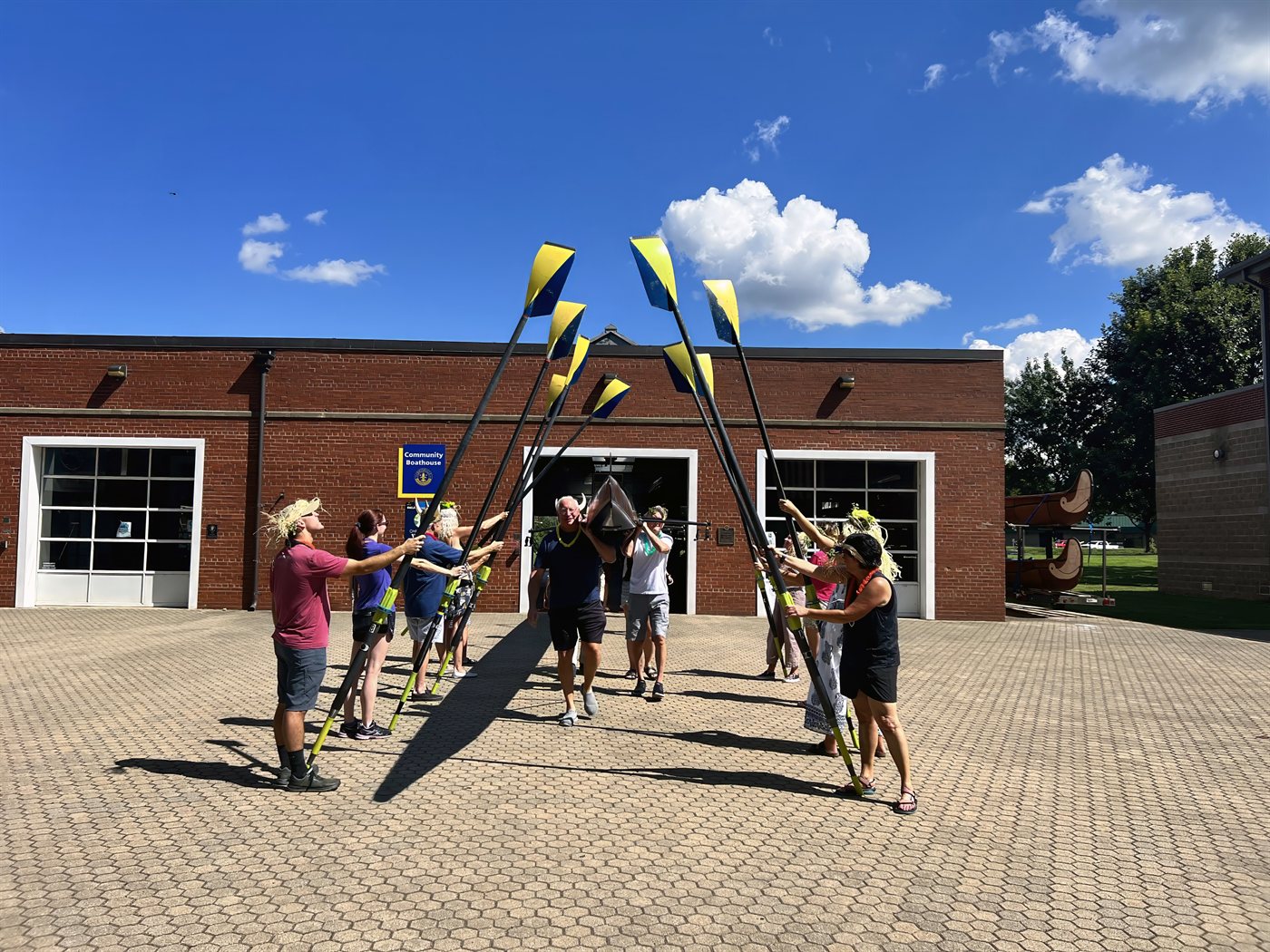 Louisville Rowing Club masters raising an arch of oars outside the Community Boathouse